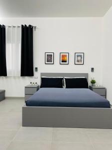 a bedroom with a large blue bed with black curtains at Sicilian Rooms in Avola