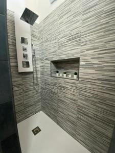 a bathroom with a shower with a stone wall at Sicilian Rooms in Avola