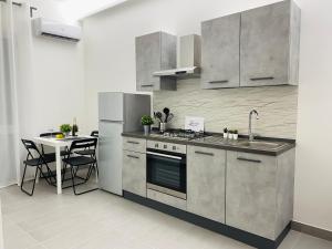 cocina con electrodomésticos de acero inoxidable y mesa en Sicilian Rooms, en Avola