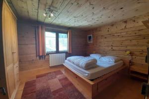ラ・クリュサにあるChalet at the foot of the Nordic domainの木製の部屋にベッド1台が備わるベッドルーム1室があります。