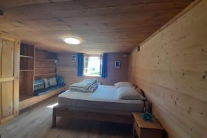 ラ・クリュサにあるChalet at the foot of the Nordic domainの木造キャビン内のベッド1台が備わるベッドルーム1室を利用します。