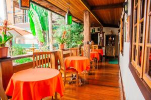 um restaurante com mesas e cadeiras com toalha de mesa laranja em Tiradentes Village em Tiradentes