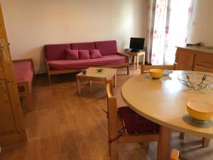 ein Wohnzimmer mit einem roten Sofa und einem Tisch in der Unterkunft Gîte indépendant avec terrasse et garage à La Chabanne - FR-1-489-187 in La Chabanne