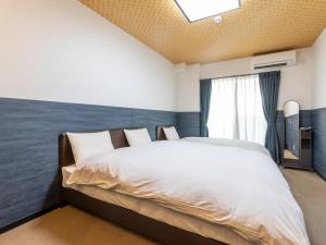 Кровать или кровати в номере Tabist Kyogura Kyoto Nijo