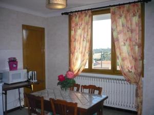 a table with a vase of flowers on it in a kitchen at Gîte Lorette, 3 pièces, 2 personnes - FR-1-496-76 in Lorette