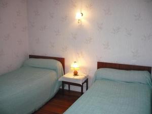 ein Schlafzimmer mit 2 Betten und einem Tisch mit einer Lampe in der Unterkunft Gîte Lorette, 3 pièces, 2 personnes - FR-1-496-76 in Lorette