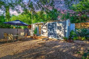 uma pequena casa com uma mesa e um guarda-chuva em Peaceful Tucson Tiny House Getaway with Backyard em Tucson