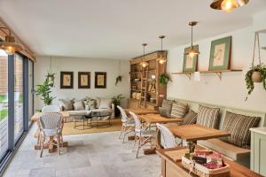 a living room with a couch and tables at Les pénates bordelaises - Maison d'hôtes - Guesthouse in Bordeaux