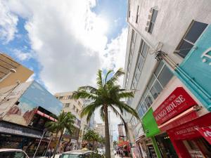 a city street with a palm tree and buildings at Hotel Gracery Naha in Naha