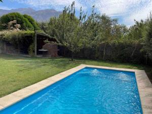 a large blue swimming pool in a yard at Linda casa en El Manzano con hermosa vista!!! in Cajon del Maipo