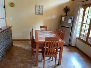 Cajon del Maipo的住宿－Linda casa en El Manzano con hermosa vista!!!，厨房配有木桌、椅子和冰箱
