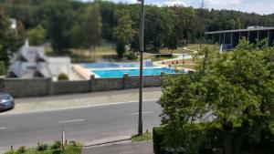 a street with a swimming pool next to a building at OPEN Vendégház in Sopron