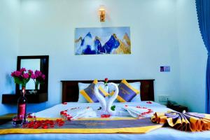 a bedroom with a bed with two swans on it at Côn Sơn Victory Hotel in Con Dao