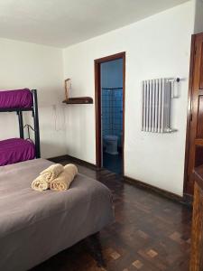 a bedroom with a bed with towels on it at Hostel Planeta Cumbrecita in La Cumbrecita