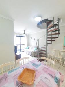 a living room with a room with a spiral staircase at Cobertura duplex- 50m da Praia Grande- Ubatuba in Ubatuba