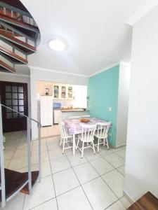 a kitchen and dining room with a table and chairs at Cobertura duplex- 50m da Praia Grande- Ubatuba in Ubatuba