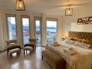 a bedroom with a large bed with a large window at Infinity View Pent House I in Ushuaia