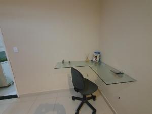 a glass desk with a chair in a room at Casa 3quartos rota Maragogi Carneiros in São José da Coroa Grande