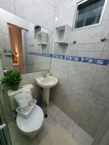 a bathroom with a toilet and a sink at Casa 3quartos rota Maragogi Carneiros in São José da Coroa Grande