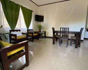 sala de estar con mesa, sillas y TV en Casa Binisa Fresca y agradable, en Liberia