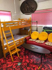 a bedroom with two bunk beds and a table at Guest in Shallman in Amami