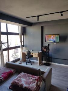 a living room with a couch and a tv on a wall at Espaço aconchegante - Centro - São Paulo in Sao Paulo
