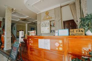 un restaurante con un mostrador de madera con un registro de impuestos en Tulip Hotel en Can Tho