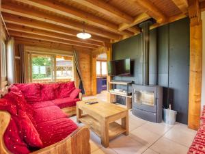 a living room with a red couch and a fireplace at Chalet Morillon Village, 6 pièces, 9 personnes - FR-1-642-66 in Morillon
