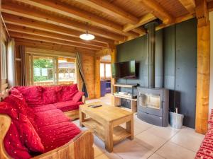 salon z czerwoną kanapą i kominkiem w obiekcie Chalet paisible à Morillon avec jacuzzi et proche des pistes skiables - FR-1-642-66 w mieście Morillon
