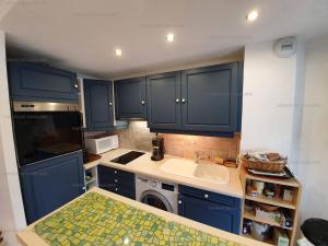 una pequeña cocina con armarios azules y fregadero en Appartement Cavalaire-sur-Mer, 2 pièces, 4 personnes - FR-1-100-277, en Cavalaire-sur-Mer