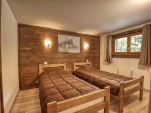 two beds in a room with wooden walls at Chalet Morillon Village, 6 pièces, 9 personnes - FR-1-642-66 in Morillon