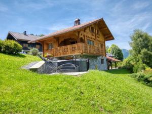 duży drewniany dom z zielonym trawnikiem w obiekcie Chalet paisible à Morillon avec jacuzzi et proche des pistes skiables - FR-1-642-66 w mieście Morillon