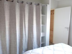 a bedroom with a bed and a shower curtain at Appartement bord de mer avec accès plage, piscine, jacuzzi, 1 chambre, animaux admis, parking inclus - FR-1-194-253 in La Tranche-sur-Mer