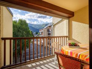 a balcony with a table and a view of the mountains at Studio pour 4 à Saint-Lary, proche centre et télécabine - FR-1-296-413 in Saint-Lary-Soulan