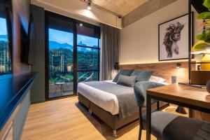 a bedroom with a bed and a large window at Hashtag 98 Hotel By Jalo in Medellín