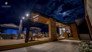 una vista notturna su un patio con tavoli e ombrelloni di Hotel Talavera Teziutlan a Teziutlán