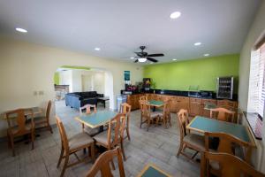 a dining room with tables and chairs and a kitchen at Ocean Breeze Inn in Saint Augustine Beach