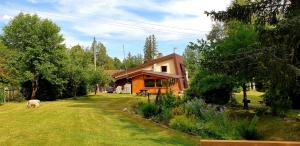 a house with a dog laying in the yard at Chata Anna in Nižné Hágy