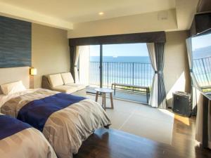 a bedroom with a bed and a view of the ocean at REX HOTEL Beppu in Beppu