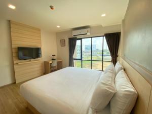 sypialnia z dużym białym łóżkiem i telewizorem w obiekcie Mayuu Ayutthaya Hotel w mieście Ban Ko Rian