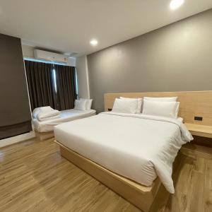 Un dormitorio con una gran cama blanca y una ventana en Mayuu Ayutthaya Hotel en Ban Ko Rian