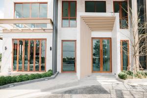 a facade of a building with glass doors at Mayuu Ayutthaya Hotel in Ban Ko Rian