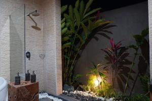 uma casa de banho com um chuveiro e um jardim em Homayoon Villa at Bisma - 10 min walking to Ubud center em Ubud