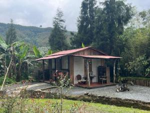 una pequeña casa en medio de un jardín en Tarragona Hostal, en Santa Rosa de Cabal