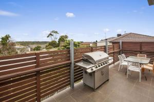 a grill on a balcony with a table and a tableablish at Bayside Haven in Portarlington