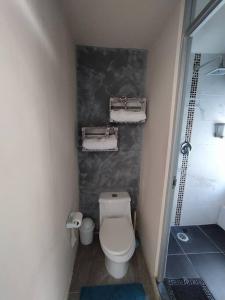 een kleine badkamer met een toilet en handdoeken bij Casa con alberca dentro de ex-hacienda en Atlixco in Atlixco