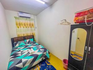 a small bedroom with a bed and a mirror at Nail Guest House Kuala Besut in Kampong Nail