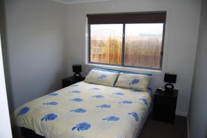 Un dormitorio con una cama con flores azules. en Time to Relax, en Portarlington