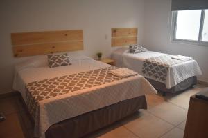 um quarto com duas camas e uma janela em El Salvador Surf Houses em Playa San Blas