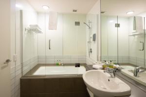 a bathroom with a tub and a sink and a shower at QS Marina in Queenstown